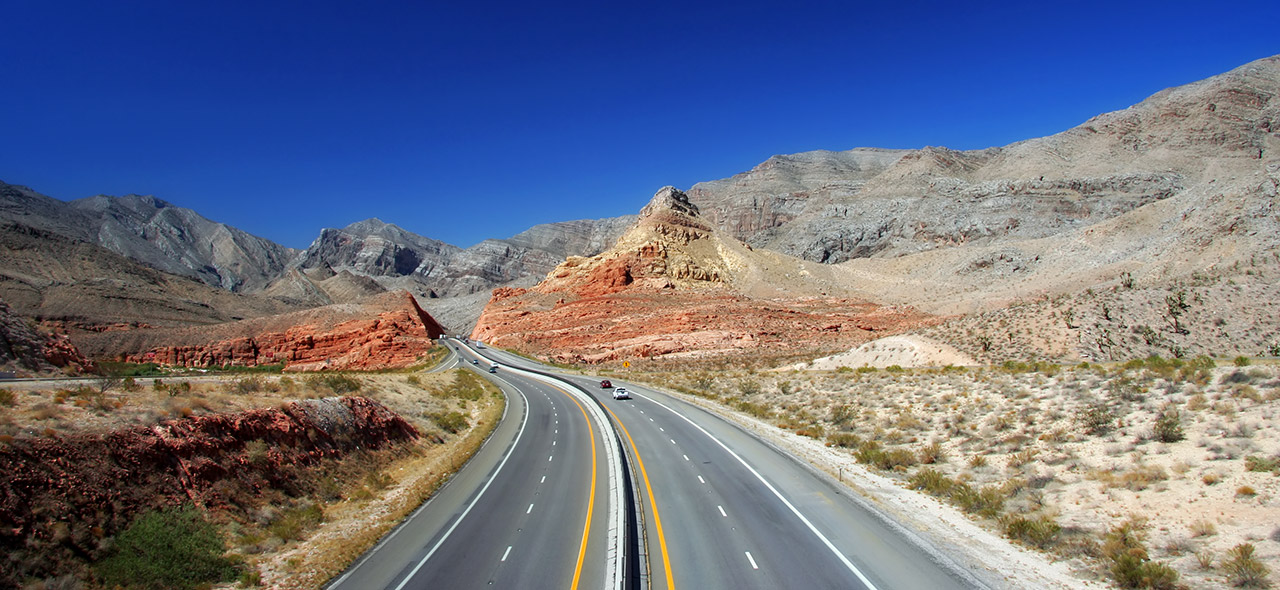 Interstate 15 on the Arizona Strip with jagged colorful mountains in an area of Arizona only accessible from Nevada or Utah