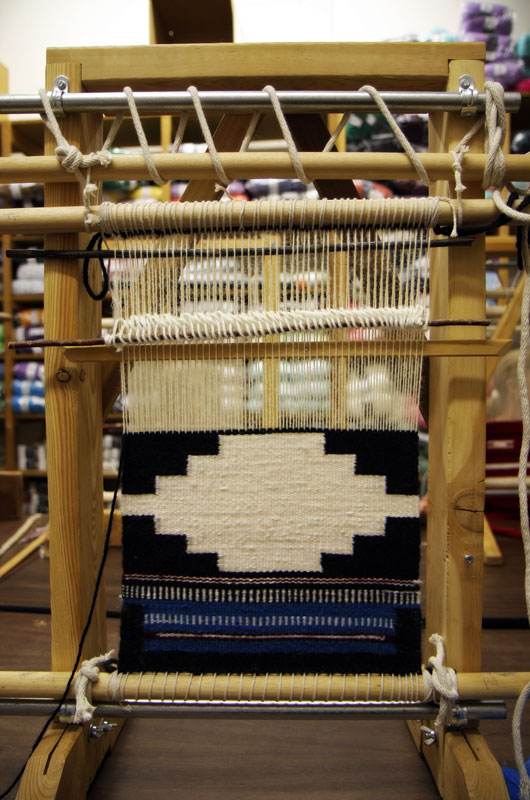 A loom with a Navajo rug in progress as being made by John Wise in Arizona