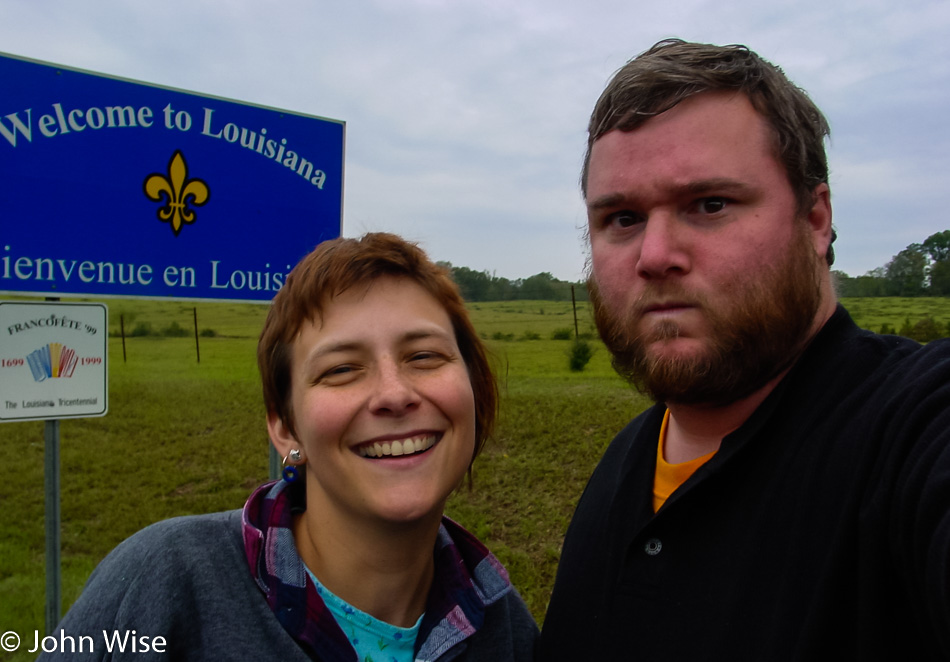 Caroline Wise and John Wise in front of the Welcome to Louisiana state sign