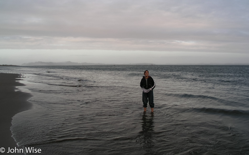 Caroline Wise standing in the surf on the Oregon coast