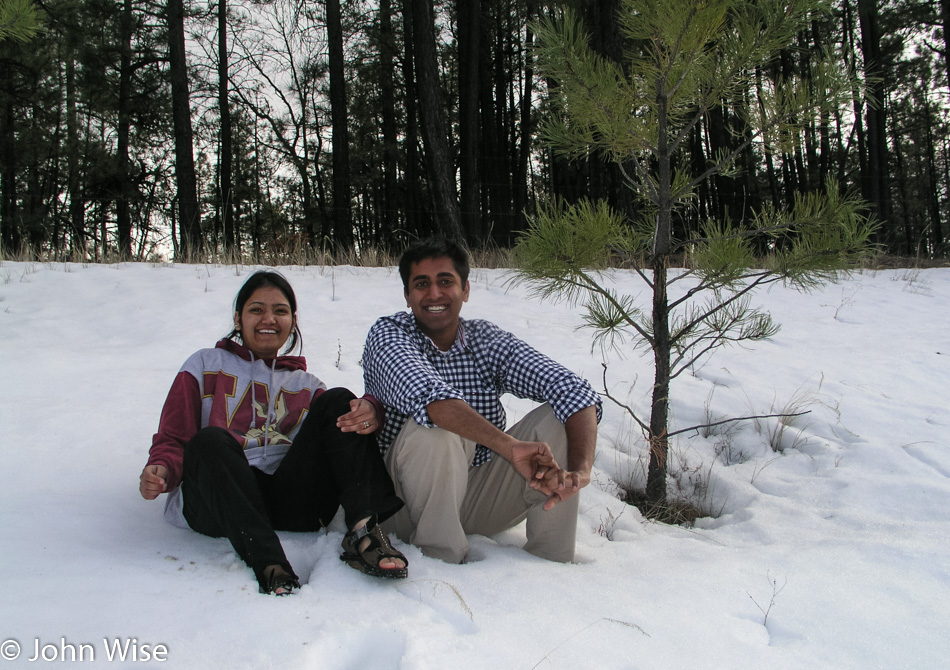 Rinku Shah and Jay Patel sitting in the snow roadside on the Arizona / New Mexico border on the way to Alpine, Arizona