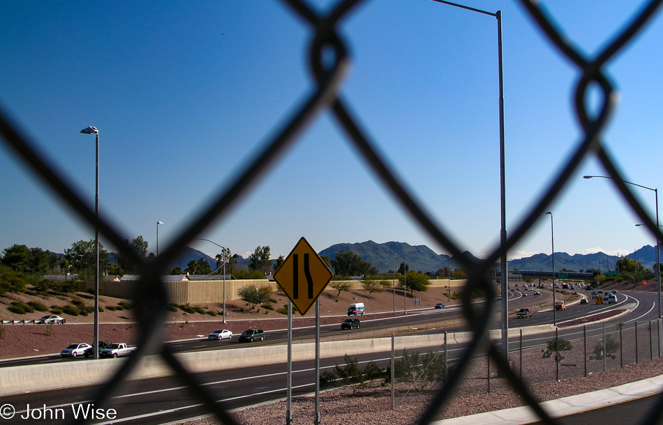 View of the 51 freeway through a chain link fence in Phoenix, Arizona