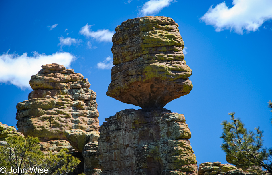 A close-up view of a balanced rock appears that a bird landing on top it could topple it at Chiricahua National Monument in Arizona
