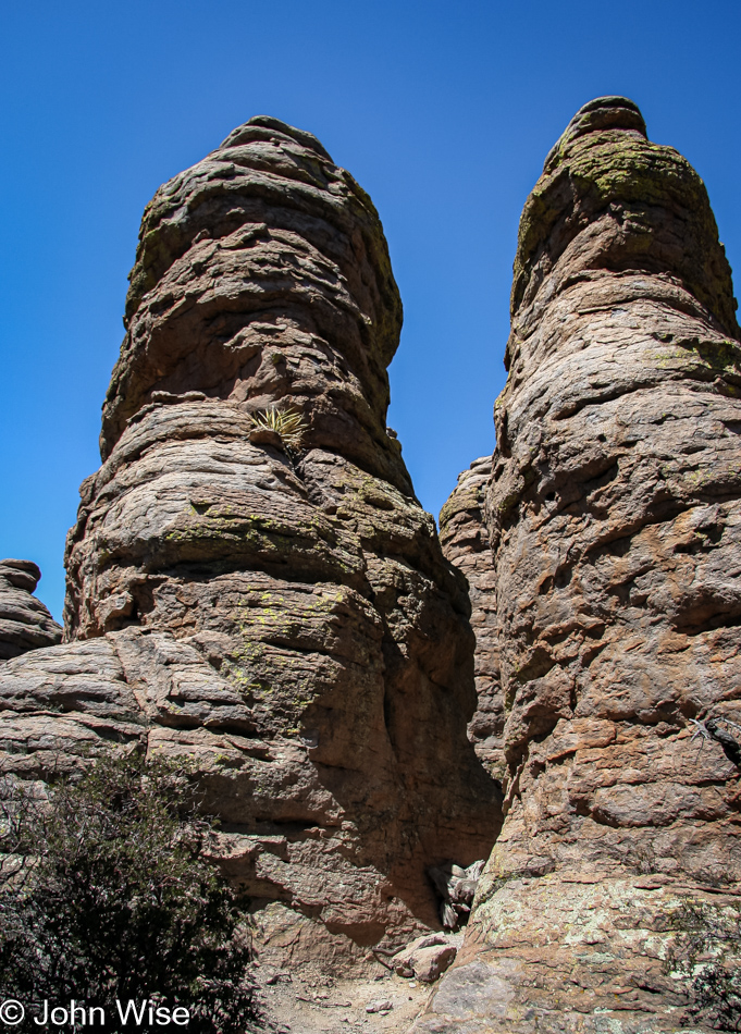 Spires towering over a narrow section of the trail in Heart of Rocks at Chiricahua National Monument in Arizona