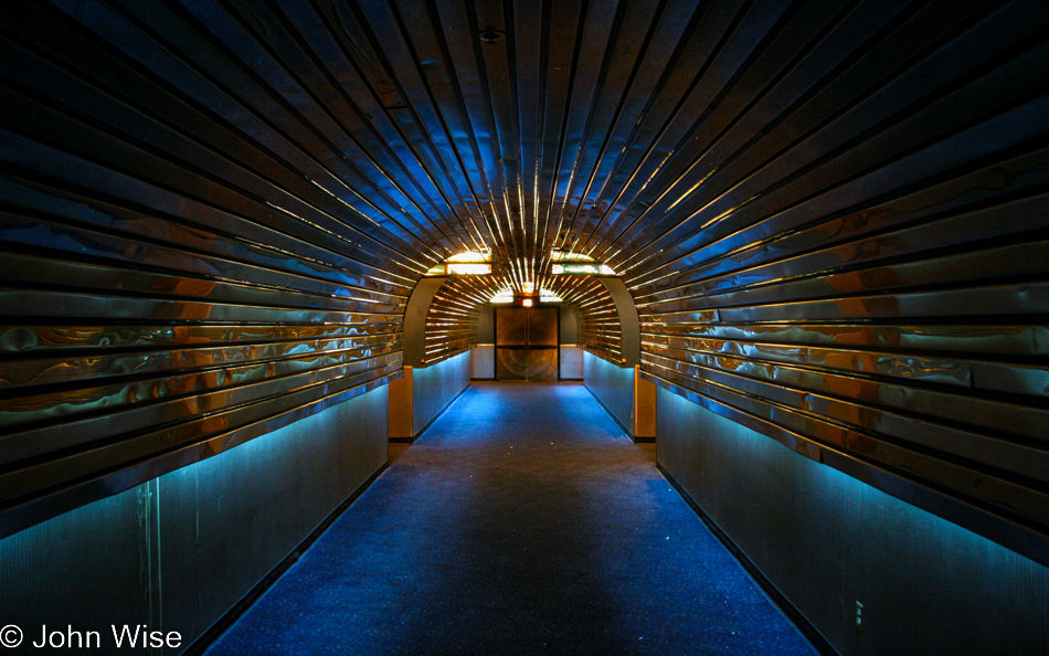 Inside a space age hallway with reflective metallic strips on a tubular shaped ceiling glow with blue lighting at Super Savers Cinema 8 discount theatres in Phoenix, Arizona
