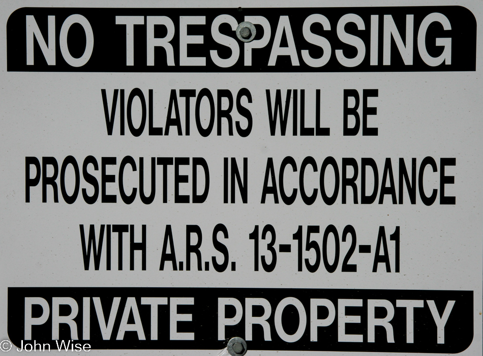 A No Trespassing sign on the side of the street in front of some townhomes in Phoenix, Arizona