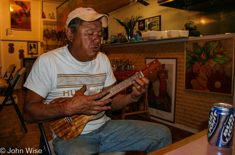 Uncle Benny (Benito Deluna) playing ukulele and singing a Hawaiian love song to Caroline and John Wise at the Kualapu'u Cookhouse on Molokai