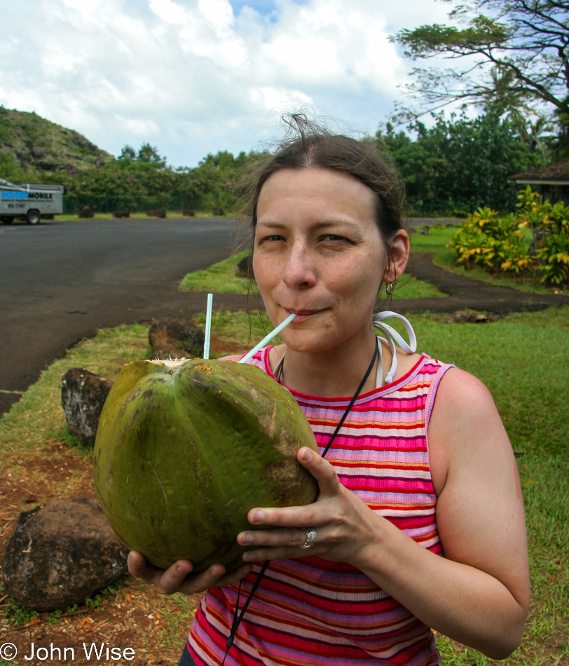 Caroline Wise enjoying a fresh coconut near 'Opaeka'a Falls in Wailua, Kauai, Hawaii