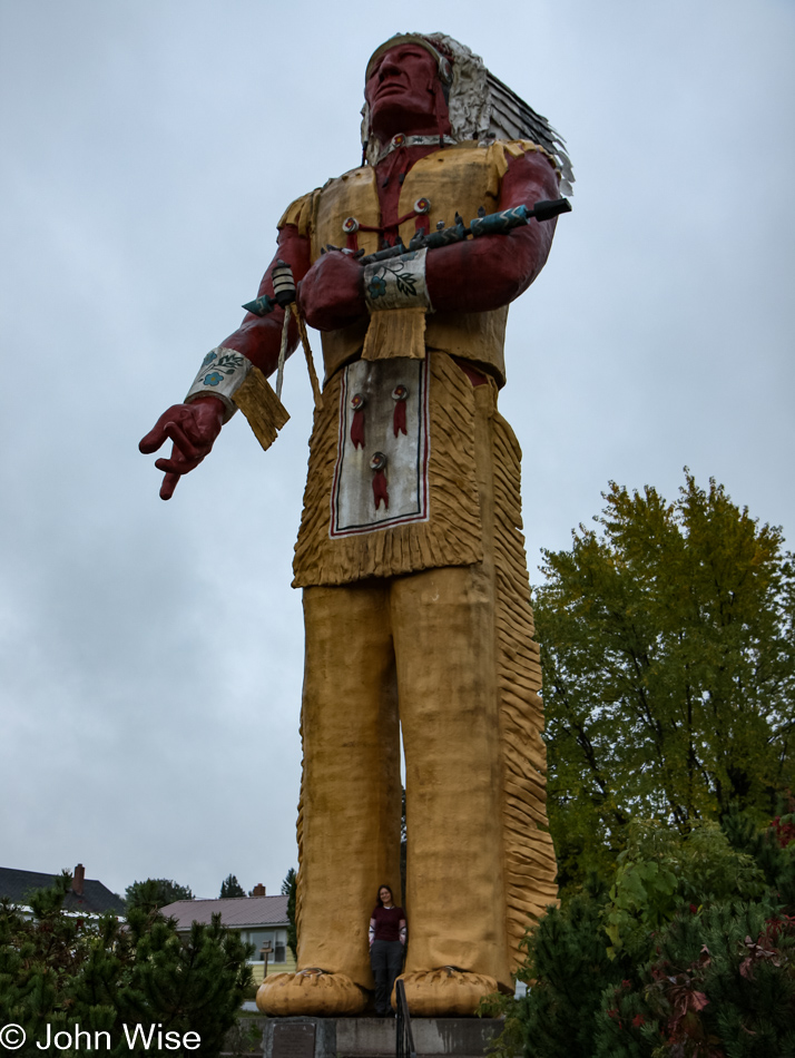 Caroline Wise standing under Hiawatha, World's Largest Indian Statue in Ironwood, Michigan