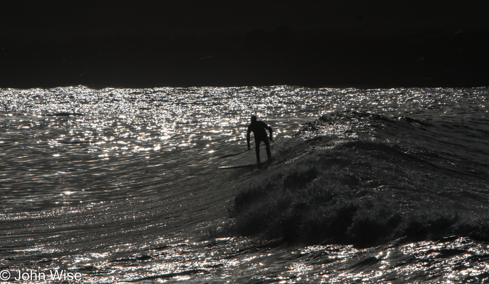 Surfer riding a wave into the outlet of the Nehalem River near Brighton, Oregon