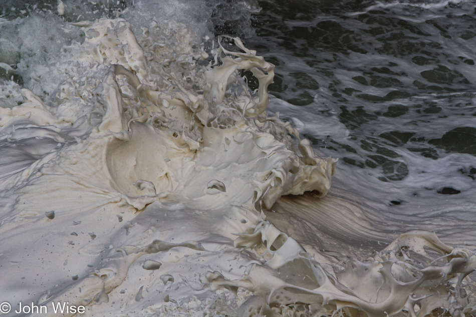 Foam being shot into the air from the roiling waves below at Devils Churn Cape Perpetua Scenic Area on the coast of Oregon