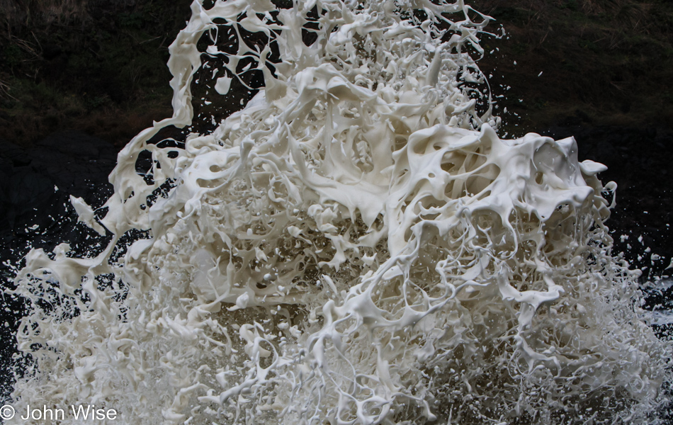 Foam being shot into the air from the roiling waves below at Devils Churn Cape Perpetua Scenic Area on the coast of Oregon