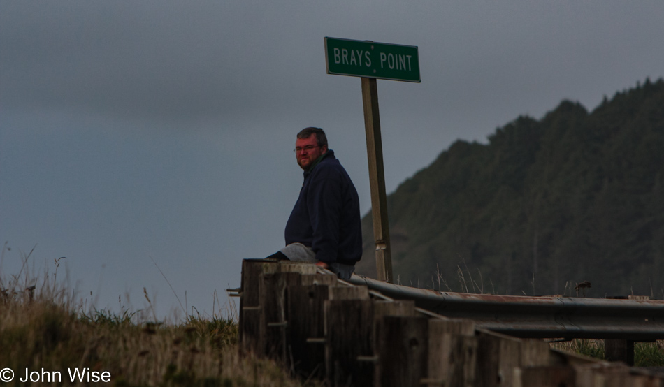 John Wise sitting next to the ocean at Brays Point, Oregon