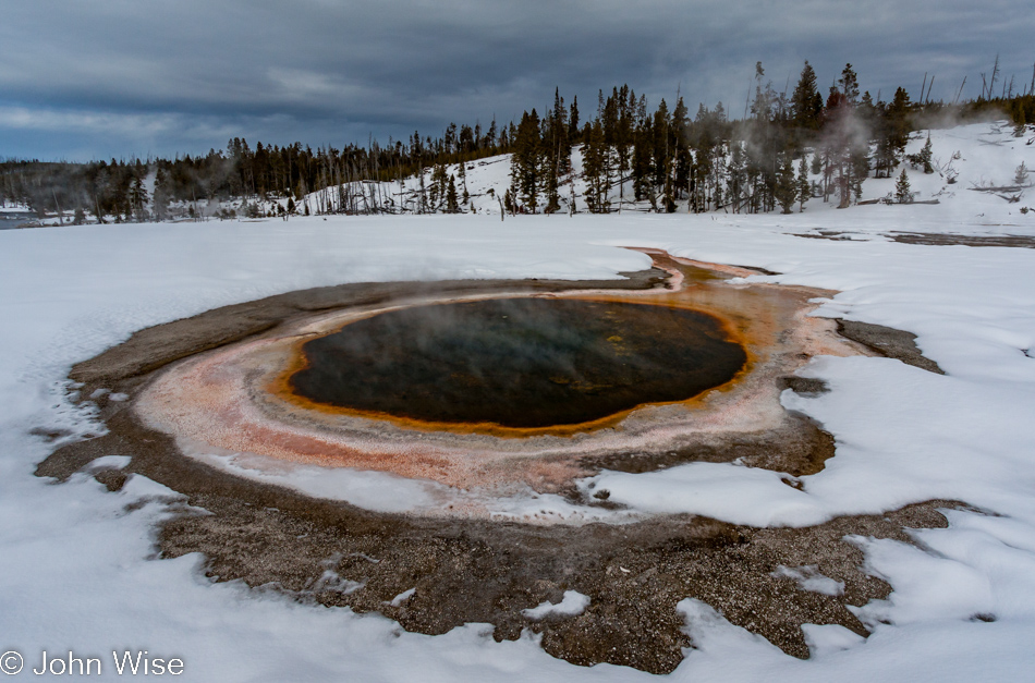 Chromatic Spring surrounded by snow on a winter day on the Upper Geyser Basin in Yellowstone National Park January 2010