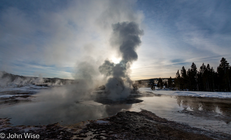Low morning sun obscured by the rising steam of Castle Geyser on the Upper Geyser Basin in Yellowstone National Park January 2010