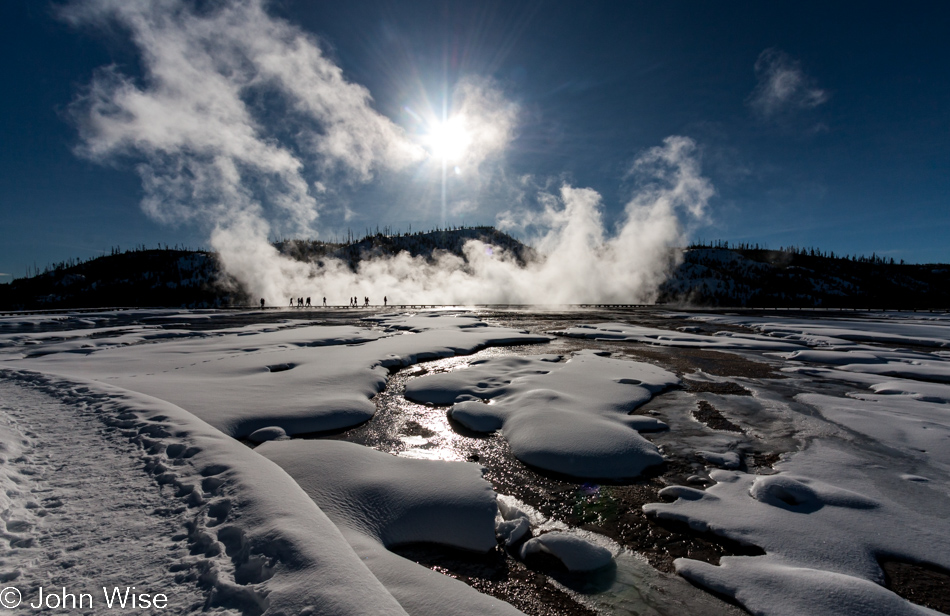 Steam rising from Grand Prismatic Spring with the sun in the background at Midway Geyser Basin in Yellowstone National Park January 2010