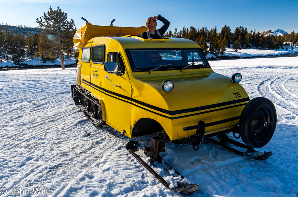 Caroline Wise searching for a good view from the open hatch of one of the historic yellow Bombardier snow coaches on the Midway Geyser Basin in Yellowstone National Park January 2010