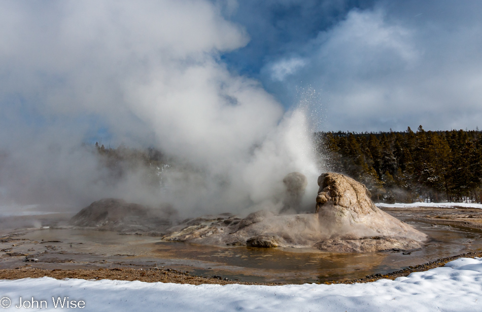 Grotto Geyser erupting on a snowy sunny moment on the Upper Geyser Basin in Yellowstone National Park January 2010