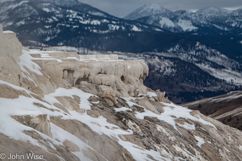 Mammoth Hot Springs terraces in the foreground with dark heavy mountains in the background at Yellowstone National Park January 2010