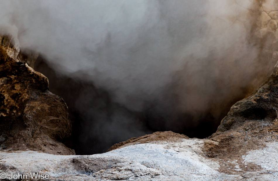 The mouth of Giant Geyser billowing steam from below on the Upper Geyser Basin in Yellowstone National Park January 2010