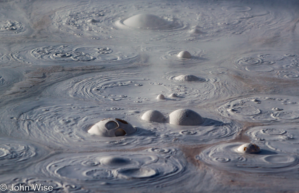 Boiling white and red tinged mud at the Fountain Paint Pots in Yellowstone National Park January 2010