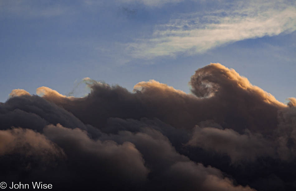 Clouds tops illuminated by the glow of sunset in southern Arizona