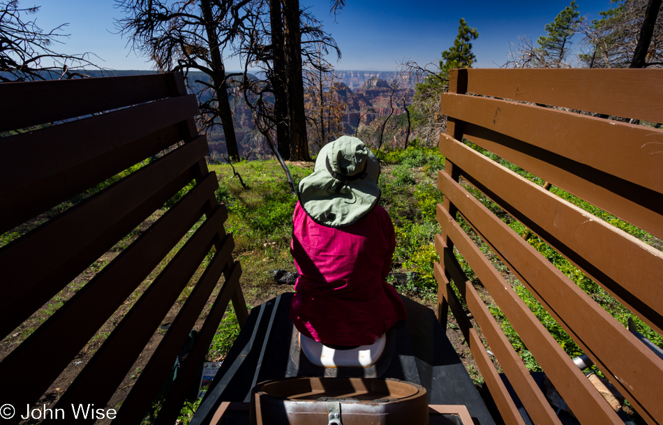 Caroline Wise sitting ring side watching the canyon form while adding to the river that cuts through it.