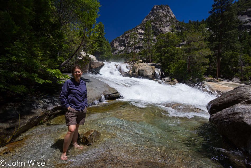 Caroline Wise standing in a pool next to a cascade above Mist Falls in Kings Canyon National Park, California