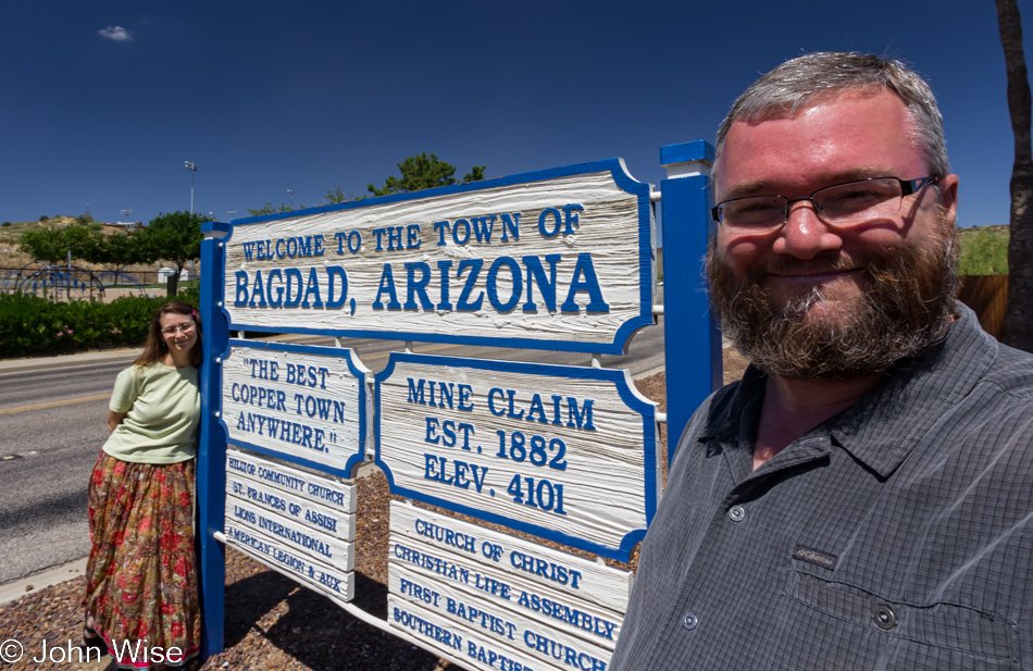 Caroline Wise and John Wise standing in front of the sign welcoming visitors to Bagdad, Arizona