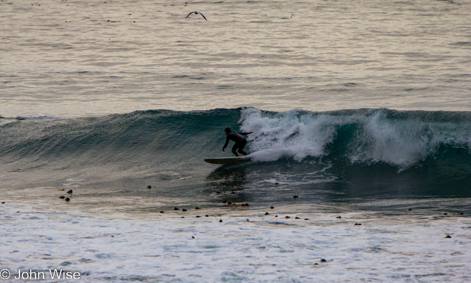 Surfer riding a wave in Big Sur, California