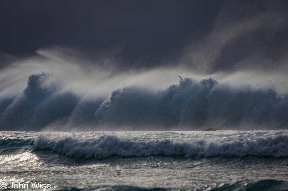 Crashing waves and blowing spray on a beach in Big Sur, California