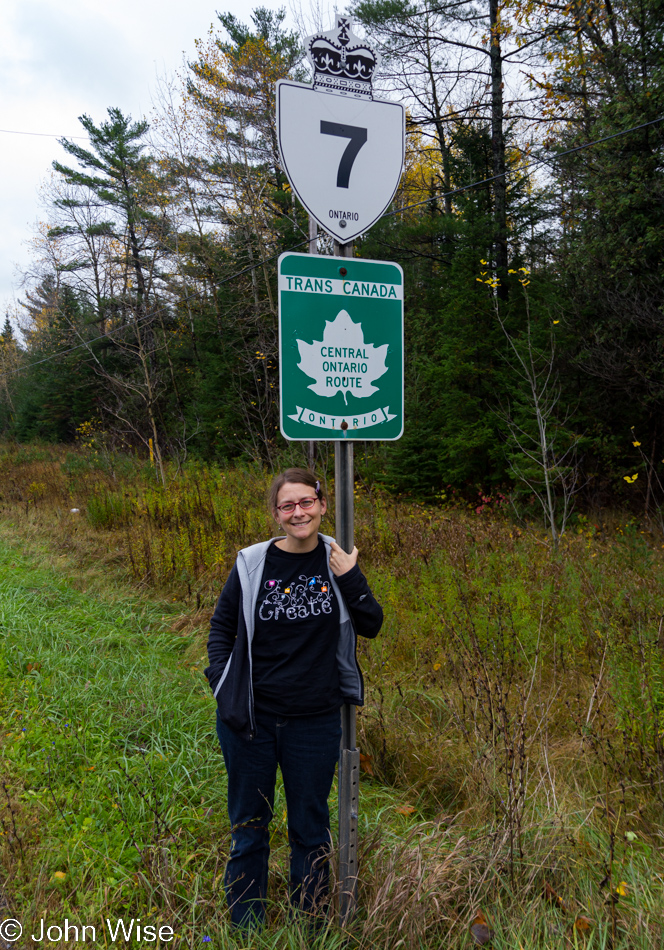 Caroline Wise in front of highway sign number 7 - the Trans Canada Highway