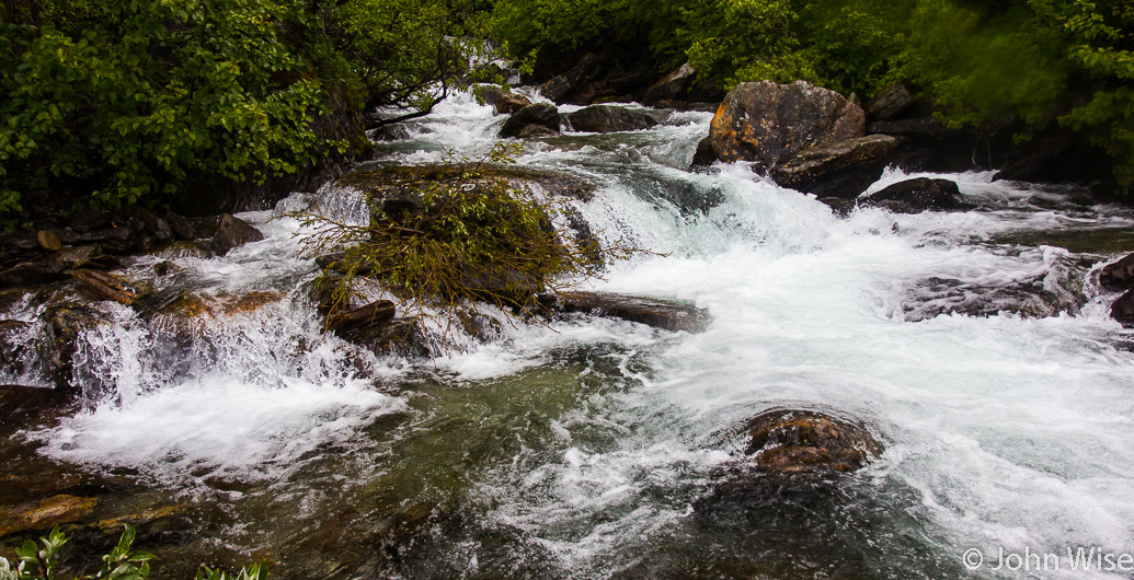 Collecting fresh water from a mountain stream crashing into the Alsek River in Alaska