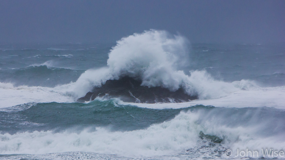 A large wave cresting a rock near Port Orford, Oregon during a blustery fall storm.