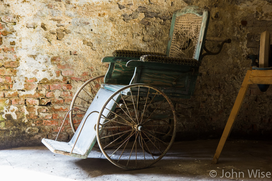 Old wheelchair sitting broken and unused in the basement of the windmill in Høyer, Denmark