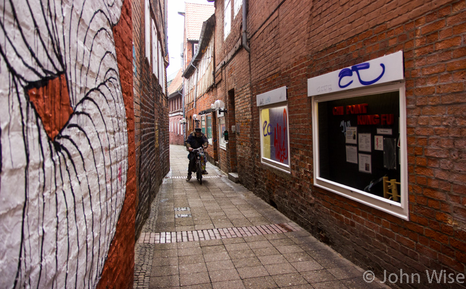 Man riding his bicycle in a narrow alley in Lüneburg, Germany