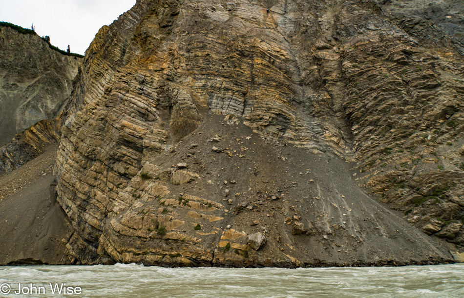 Twisting layers of sedimentary rock on the shore of the Alsek river in Canada