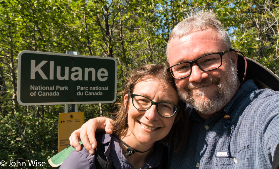 Caroline Wise and John Wise posing for a selfie in front the Kluane National Park sign in Yukon, Canada