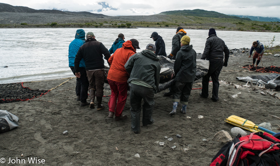 Loading rafting gear into net for heli-portage on the Alsek River in British Columbia, Canada