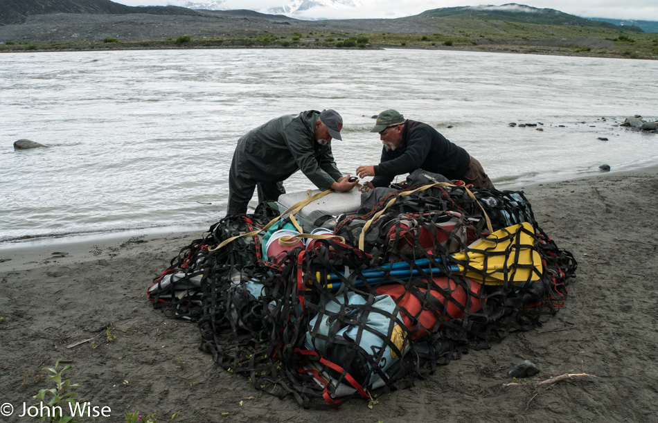 Loading rafting gear into net for heli-portage on the Alsek River in British Columbia, Canada
