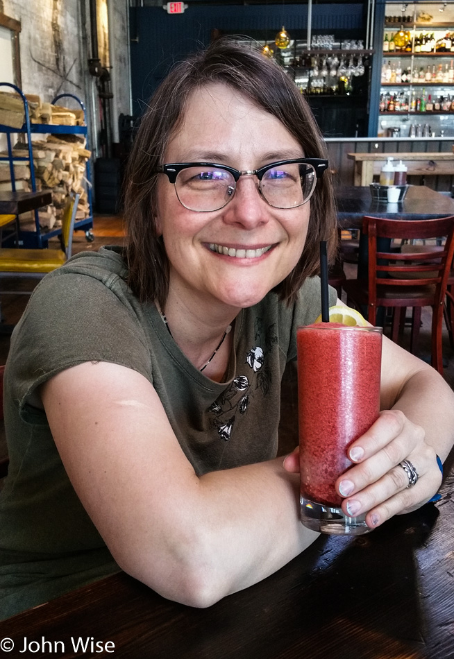 Caroline Wise drinking a bourbon cheerwine slushy at Buxton Hall BBQ in Asheville, North Carolina