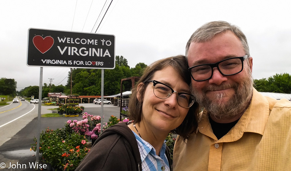 Caroline Wise and John Wise in front of a Welcome to Virginia state sign