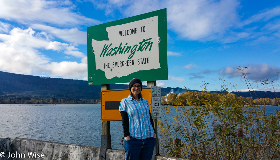 Caroline Wise in front of a Welcome to Washington state sign