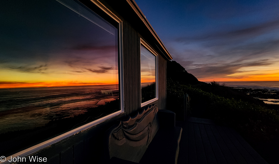 Sunset reflected in the windows of the Shags Nest at Ocean Haven in Yachats, Oregon