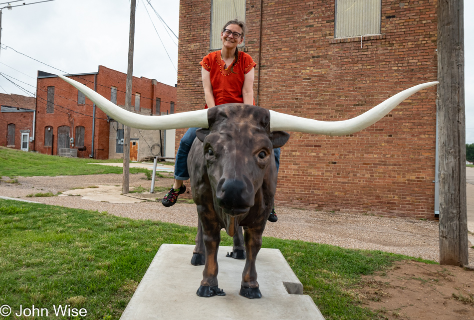 Caroline Wise on a steer statue in Miami, Texas